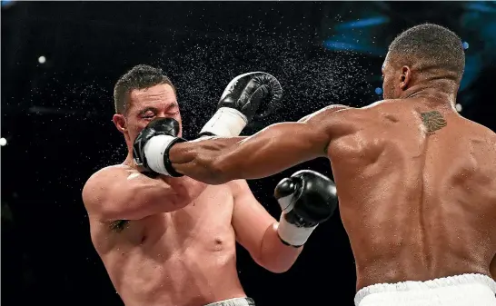  ?? PHOTO: PHOTOSPORT ?? Joseph Parker cops a left to the face from Anthony Joshua during their unificatio­n title fight. ‘‘I have to take it on the chin,’’ the New Zealander said of his defeat.