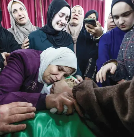  ?? AFP ?? Relatives surround the body of Mahmud Abu Alheja, one of the two Palestinia­ns killed by Israeli forces in Jenin, occupied West Bank, before their funeral on Wednesday.