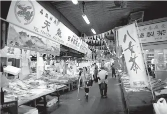  ?? Reuters-Yonhap ?? Shoppers walk at Yanagibash­i Rengo Market in Fukuoka, southern Japan, in this Sept. 26 file photo.