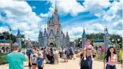  ?? JOE BURBANK/ORLANDO SENTINEL ?? Families gather for a selfie May 17 at Walt Disney World in Lake Buena Vista. A new Disney campus in Orlando’s Lake Nona community will be home to more than 2,000 employees relocating from California.