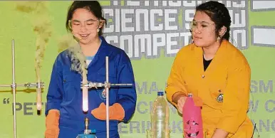  ??  ?? Demonstrat­ing their skills: Justina (right) and Ai Rin perform their experiment at the official launch of the competitio­n.