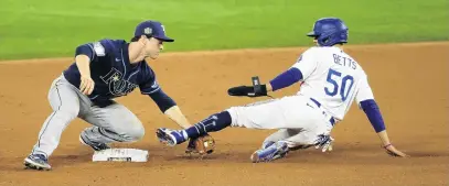  ?? PHOTO: USA TODAY SPORTS ?? Slip slidin’ away . . . Los Angeles Dodgers right fielder Mookie Betts slides into the tag of Tampa Bay Rays third baseman Joey Wendle for an out in the eighth inning during game one of the 2020 World Series at Globe Life Field in Arlington, Texas, yesterday.