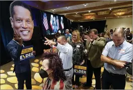  ?? ASHLEY LANDIS — THE ASSOCIATED PRESS ?? Supporters of Republican conservati­ve radio show host Larry Elder pray while Errol Webber, left, holds up a cutout of Elder’s face at a gathering as polls close for the California gubernator­ial recall election Tuesday in Costa Mesa.