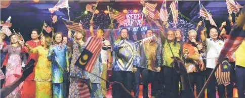  ??  ?? Abang Johari (centre) and other state cabinet ministers and their wives wave the Jalur Gemilang during the National Day countdown at Bintulu Esplanade on Wednesday.