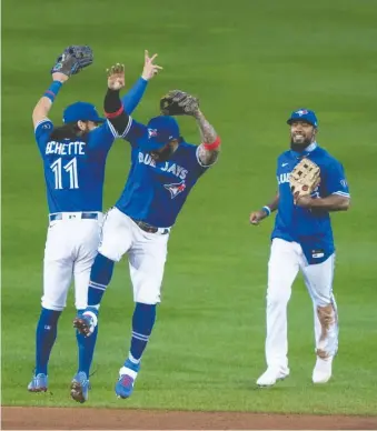  ?? GREGORY FISHER/ USA TODAY SPORTS FILES ?? Toronto Blue Jays teammates, from left, Bo Bichette, Jonathan Villar and Teoscar Hernandez celebrate after beating the Yankees late last season to clinch a playoff spot.