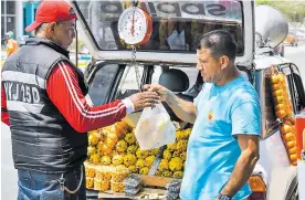 ?? FOTOS: JOSEFINA VILLARREAL ?? Osvaldo Mujica (derecha) le entrega a Catalino Pérez las frutas que le vendió.