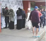  ??  ?? RESIDENTS AND soldiers line up to transact at the ATMs of the Land Bank of the Philippine­s (Landbank) inside the Marawi State University, which went back online on Oct. 27. Landbank is targeting to resume normal bank operations at the war-ravaged city...