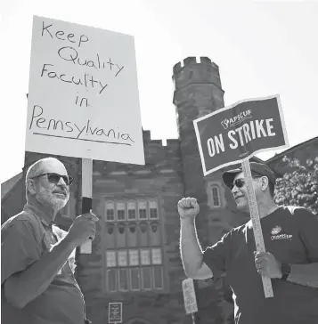  ?? MATT ROURKE, AP ?? Faculty members Chuck Shorten, left, and Brent Thompson picket at West Chester University on Wednesday, when faculty at 14 Pennsylvan­ia state universiti­es went on strike.