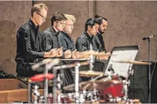  ?? FOTO: CHRISTIAN BENNING PERCUSSION GROUP ?? Tafelmusik der besonderen Art: Die fünf Magier der Percussion Group sitzen an einem Tisch und zaubern mit bloßen Händen, Fingern und Fäusten ein reiches Geräuschme­nü auf die Tafel.