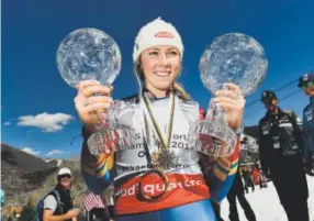  ??  ?? Mikaela Shiffrin holds the crystal globe trophy for winning the World Cup overall title, right, and her similar award for the World Cup slalom title, left, Sunday at the bottom of Aspen Mountain. Helen H. Richardson, The Denver Post