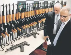  ??  ?? Rio de Janeiro’s Security Secretary Roberto Sa (right) and Civil Police chief Carlos Leba walk past weapons which were seized in Rio de Janeiro’s internatio­nal airport during their presentati­on, Brazil.