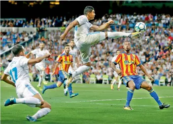  ??  ?? Real Madrid’s Casemiro jumps to kick a big ball during their Spanish League match against Valencia at the Santiago Bernabeu in Madrid on Sunday. The match ended in a 2-2 draw.
