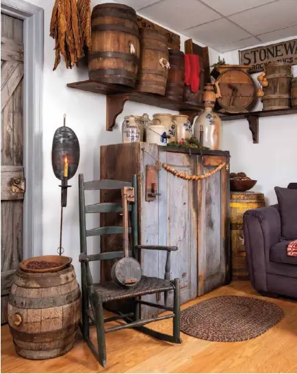  ??  ?? Left: In her living room, Linda lined up casks and barrels on a high, sturdy shelf to fill vertical space above a floor-set cupboard. She placed bigger barrels in a corner and next to a chair to double as side tables.