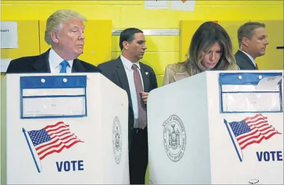  ?? CARLO ALLEGRI / REUTERS ?? Donald Trump mirando con curiosidad –¿inquisitor­ial?– lo que vota su esposa, Melania, ayer en Nueva York