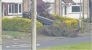  ??  ?? Overturned The car ended up on its roof after ploughing through a garen