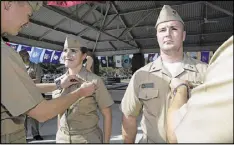  ??  ?? Lt. j.g. Marquette Leveque, left, and Lt. j.g. Kyle McFadden, of the USS Wyoming, receive pins to indicate that they’re qualified to serve on submarines. Leveque is one of the first women to serve on a submarine.