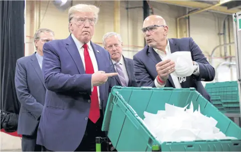  ?? REUTERS ?? US President Donald Trump points at a face mask being shown to him at Honeywell’s facility manufactur­ing protective masks in Phoenix on Tuesday.