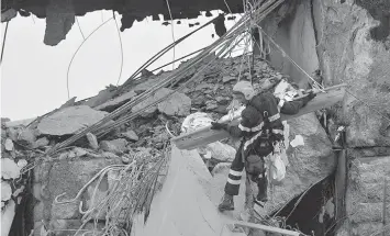  ?? ASSOCIATED PRESS ?? Firefighte­rs rescue a person from the rubble of the collapsed Morandi highway bridge in Genoa, northern Italy. A large section of the bridge collapsed over an industrial area in the Italian city of Genova during a sudden and violent storm, leaving vehicles crushed in rubble below.