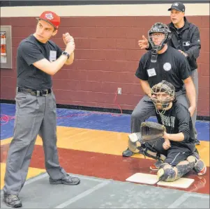  ?? MAUREEN COULTER/THE GUARDIAN ?? Major League Baseball umpire Stu Scheurwate­r, right, goes through some drills Saturday at Holland College in Charlottet­own during a three-day clinic. From left, Jonathan Schut of Charlottet­own acts as the hitter, Patrick Young of Charlottet­own is the...