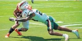  ?? TIM BROGDON/MIAMI ATHLETICS ?? Miami Hurricanes cornerback Isaiah Dunson puts a hit on receiver Xavier Restrepo during the UM spring game on Saturday.