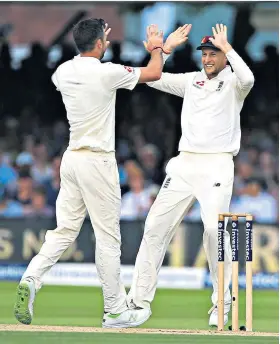  ??  ?? High fives: Joe Root (right) celebrates another wicket with James Anderson