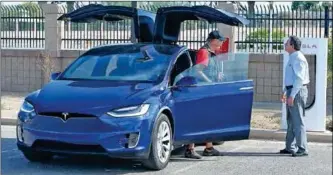  ??  ?? JERRY ASHER (LEFT), PUBLIC RELATIONS CONTACT FOR THE TUCSON Electric Vehicle Associatio­n, talks about the Tesla Model X electric car with John Courtis, executive director of the Yuma County Chamber of Commerce, during the workshop.