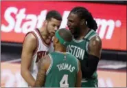  ?? CHARLES REX ARBOGAST — THE ASSOCIATED PRESS ?? The Bulls’ Michael Carter-Williams, left, has words with the Celtics’ Isaiah Thomas (4) as Jae Crowder comes between the pair during the second half Sunday.