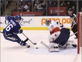  ?? RICHARD LAUTENS, TORONTO STAR ?? Maple Leafs centre Mitchell Marner drives to the net and scores a late first-period goal on Florida Panthers goalie James Reimer in National Hockey League action at Air Canada Centre in Toronto on Thursday night. Toronto won the contest, 6-1, with...