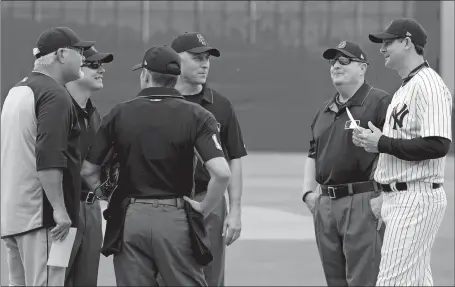  ?? LYNNE SLADKY/AP PHOTO ?? Yankees manager Aaron Boone, right, and Tigers manager Ron Gardenhire meet with the umpires Friday before their exhibition game in Tampa, Fla. Boone’s first baseball game at any level as manager was an early success; New York beat Detroit, 3-1.