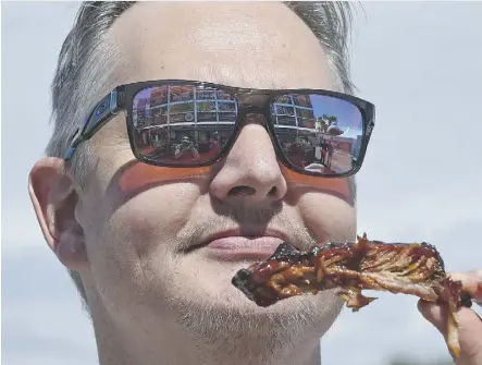  ?? ED KAISER ?? Micheal Monaghan savours an offering from one of the rib vendors at K-Days Ribfest.