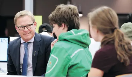  ?? GAVIN YOUNG ?? Education Minister David Eggen speaks with Dr. E.P. Scarlett High School students taking part in the Calgary Board of Education’s Worktopia program on Wednesday. The unique program helps autistic high school kids prepare for graduation by giving them a chance to learn workplace skills.