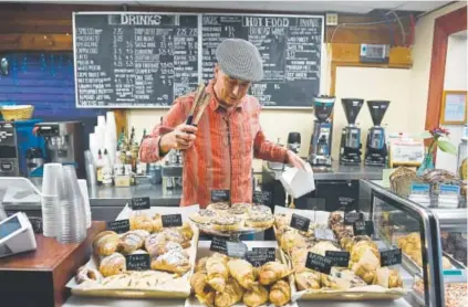  ?? Helen H. Richardson, The Denver Post ?? New Moon Bakery owner Peter Stader looks over a variety of goods at the bakery.