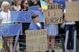  ?? OLIVIER MATTHYS — THE ASSOCIATED PRESS ?? Protestors in support of Ukraine stand with signs and EU flags during a demonstrat­ion outside of an EU summit in Brussels on Thursday.