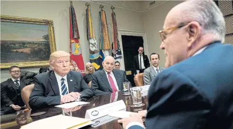  ?? AFP ?? US President Donald Trump, left, listens while former New York Mayor Rudy Giuliani, right, speaks during a meeting on cyber security.