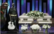  ?? MARK HUMPHREY — THE ASSOCIATED PRESS ?? A Batman costume and guitar stand next to the casket during a memorial service for country music singer Troy Gentry, shown at left, at the Grand Ole Opry House Thursday in Nashville, Tenn. Gentry, who was a fan of Batman and made up the duo Montgomery...