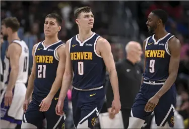  ?? AARON ONTIVEROZ — THE DENVER POST ?? Collin Gillespie (21)Christian Braun (0) and Justin Holiday (9) of the Denver Nuggets walk to the bench during the second quarter against the Sacramento Kings at Ball Arena in Denver on Wednesday, Feb. 14, 2024.