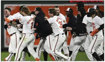  ?? (AP/Nick Wass) ?? Baltimore Orioles catcher James McCann (left), a former Arkansas Razorback, celebrates with shortstop Gunnar Henderson and other teammates after hitting a game-winning two-run single with two outs in the bottom of the ninth inning to defeat the Kansas City Royals 4-3 on Wednesday night at Camden Yards in Baltimore.
