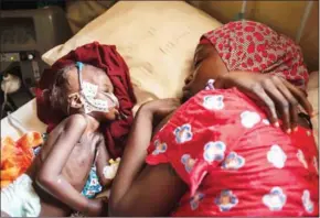  ?? STEFAN HEUNIS/AFP ?? A woman and a young child suffering from severe malnutriti­on sleep on a bed in the ICU ward at the In-Patient Therapeuti­c Feeding Centre in the district of Maiduguri, Borno state, northeaste­rn Nigeria, on September 17.