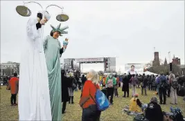  ?? Jacquelyn Martin ?? The Associated Press Carolyn Mccarthy, dressed on stilts as “Lady Justice,” left, and Debbie Davis, dressed as “Lady Liberty,” both of Milwaukee, Wis., attend the A.C.T. To End Racism rally Wednesday on the National Mall in Washington.