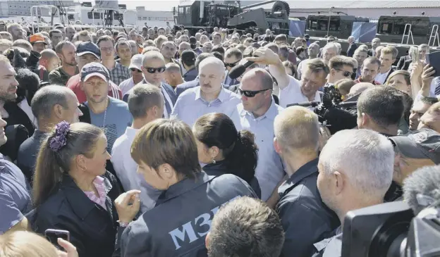  ??  ?? 0 Belarusian president Alexander Lukashenko, centre, is surrounded by angry employees as he visited the Minsk Tractor Plant