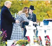  ??  ?? EMOTIONAL – First Lady Melania Trump, assisted by President Donald Trump, places a white flower at a memorial for those who were killed at the Tree of Life Synagogue in Pittsburgh, October 30. With them is Tree of Life Rabbi Jeffrey Myers. (AP)