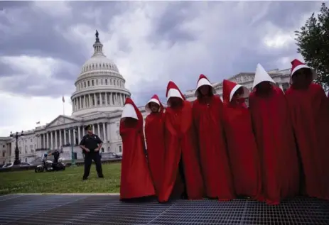  ?? ERIC THAYER/THE NEW YORK TIMES ?? Costumed protesters inspired by the dystopian book and television show The Handmaid’s Tale take a stand against the health care bill on Capitol Hill.
