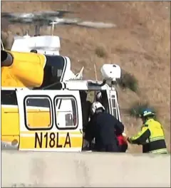  ?? Austin Dave/The Signal ?? Emergency response crews help one of the victims of a car crash on Highway 14 board Copter 18 on Thursday. Two adults and two children were injured in the crash. Authoritie­s are looking into racing as a cause of the crash.