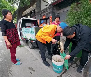  ??  ?? À Beijing, un triporteur électrique sillonne les ruelles afin de récupérer les déchets alimentair­es des foyers.