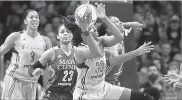  ?? Gina Ferazzi Los Angeles Times ?? NNEKA OGWUMIKE hangs on to an offensive rebound in front of Minnesota’s Maya Moore (23) and Rebekkah Brunson, but the Lynx grabbed 16 more of them than the Sparks in Game 4 in the WNBA Finals.