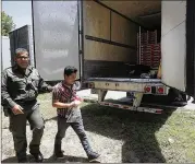  ?? DELCIA LOPEZ / THE MONITOR ?? A Border Patrol officer escorts an immigrant Sunday to a van in Edinburg. He was one of 17 people found locked inside a tractor-trailer parked at a gas station about 20 miles from the Mexican border.
