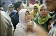  ?? HADI SUTRISNO — THE ASSOCIATED PRESS ?? A relative of passengers prays Monday as she and others wait for news on a Lion Air plane that crashed off Java Island at Depati Amir Airport in Pangkal Pinang, Indonesia.