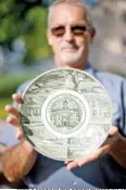  ?? DREW C. ROBINSON/THE CITIZEN TRIBUNE VIA AP ?? Terry Myers, maintenanc­e supervisor at the Hamblen County Courthouse, holds a commemorat­ive plate salvaged from a time capsule buried in 1970 in Morristown, Tenn.