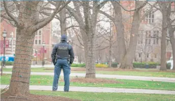  ??  ?? A police officer stands watch Monday on the campus of the University of Chicago.