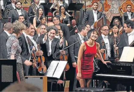  ?? ANTONI BOFILL / PALAU DE LA MÚSICA ?? Gustavo Dudamel, en el centro, saludando al final del concierto en el Palau, junto a la pianista Yuja Wang